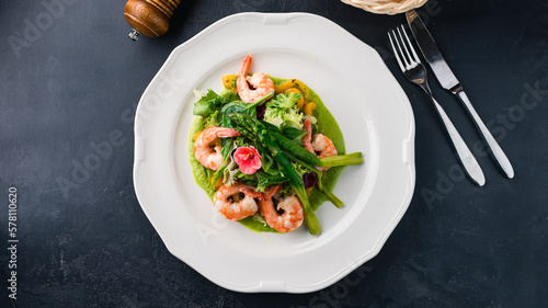 Salad with shrimps, asparagus, lettuce and green sauce.