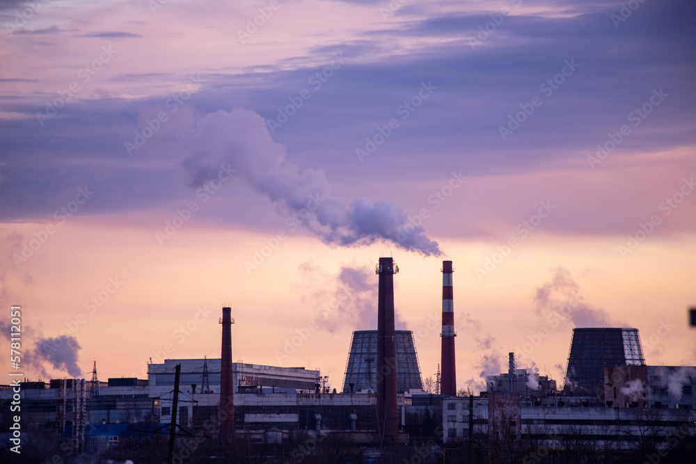 Industrial landscape, smoke from chimneys in the industrial area of the city at sunset