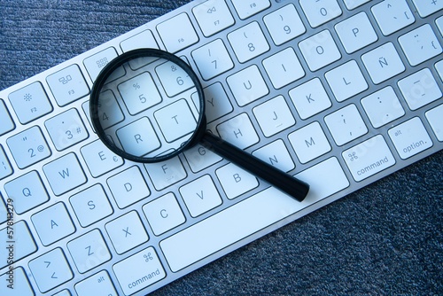 Close-up of keyboard and magnifying glass.