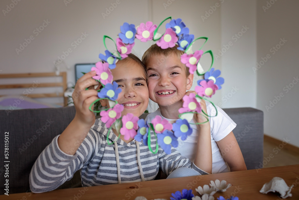 Fototapeta premium DIY project with kids, an egg carton is transformed into Easter flower wreath. Creativity and sustainability that come with a Zero Waste lifestyle. Reduce, reuse, and recycle