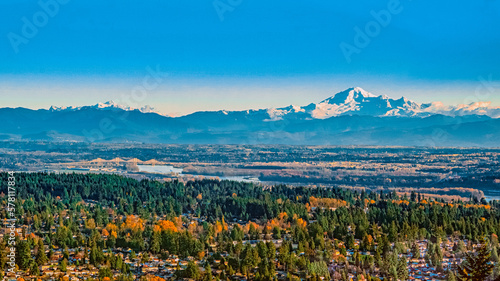 Scenic Fall view of Fraser Valley from University Highlands on Burnaby Mountain, BC, with Fraser River in center and alpine mountain backdrop.