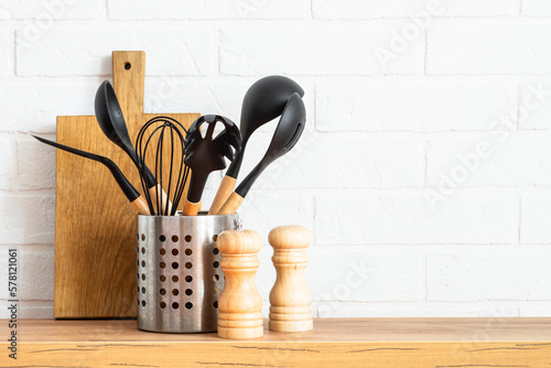 Kitchen utensils. Cooking tools with wooden cutting boards, oil and shaker at white modern kitchen interior. photo