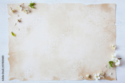 Wooden white background with spring flowers blooming cherry plum, paper with copy space, for text greetings