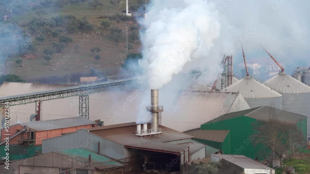Factory expelling pollution and smoke through a chimney. Environmental problem Factory expelling pollution and smoke through a chimney. Environmental problem