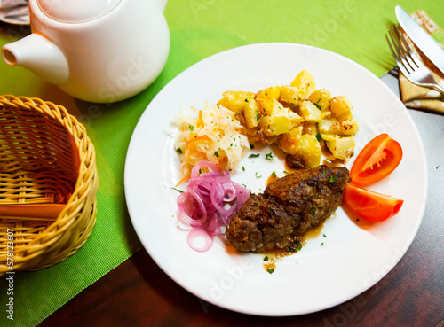 Delicious meat dish lula-kebab with stewed potatoes, pickled cabbage, onions and fresh tomatoes...