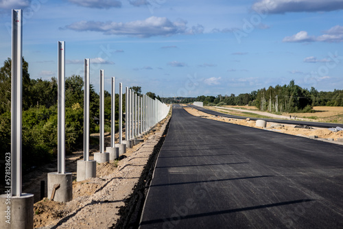 Budowa nowej autostrady. Monta   barier ochronnych i znak  w przy nowo budowanej autostradzie. Nowy asfalt.