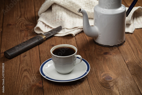 cup of coffee and vintage coffeepot on wooden table.