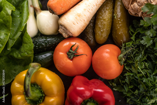 Świeże surowe warzywa na ciemnym rustykalnym tle. Składniki zdrowej diety wegańskiej.