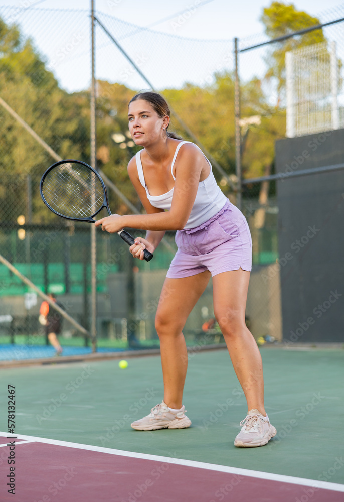 Portrait of sporty focused woman playing on court, ready to hit ball. Active lifestyle concept