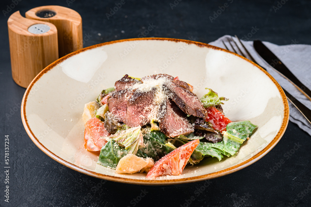 Meat salad with beef slices, tomatoes, parmesan cheese, pickled cucumber, lettuce and sauce. Meat salad with beef slices, tomatoes, parmesan cheese, pickled cucumber, lettuce and sauce.