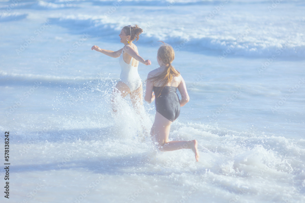 happy stylish mother and child at beach running happy stylish mother and child at beach running