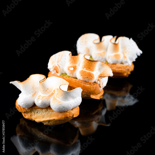 Sweet mini eclairs with pistachio and seared meringue.