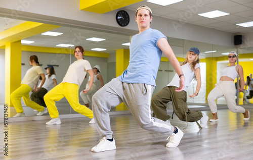 Fototapeta Naklejka Na Ścianę i Meble -  Dynamic teenage boy training breakdance Toprock moves during workout session. Teens doing breakdance in dance hall