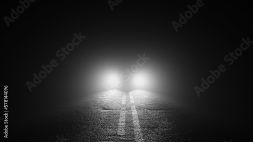 Black and white image of an ominous car parked in middle of road at night shining blinding headlights	
