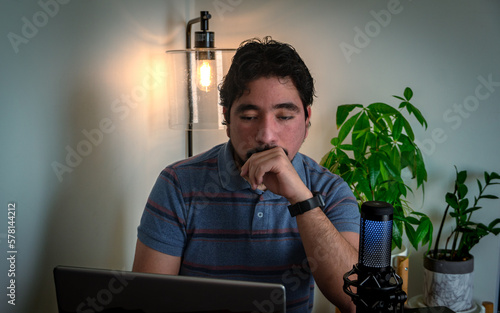 Joven adulto hispano trabajando desde casa computador personal 