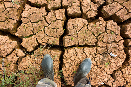 Foto Walking along the bottom of a dried-up reservoir with cracks in the drying of cl