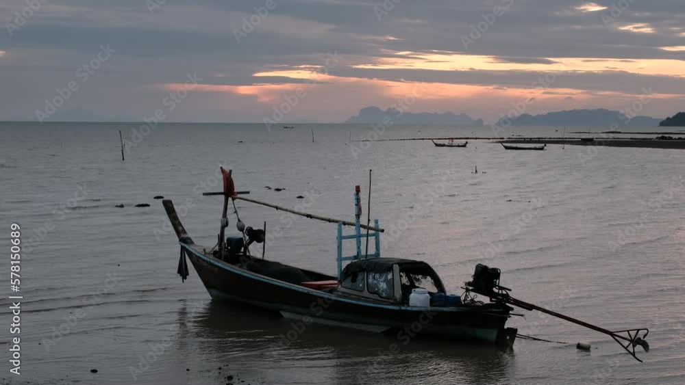 Tripod shot of traditional thai longtail boat in the sea at sunrise. Ko Lanta Old Town, Thailand. Tripod shot of traditional thai longtail boat in the sea at sunrise. Ko Lanta Old Town, Thailand.