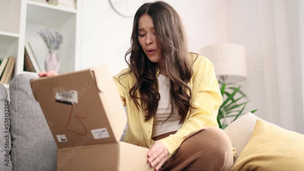 Charming young caucasian woman received parcel satisfied with purchase order shopping in kids newborn online internet store hold cute little rompers at home Preparing for motherhood concept Charming young caucasian woman received parcel satisfied with purchase order shopping in kids newborn online internet store hold cute little rompers at home Preparing for motherhood concept
