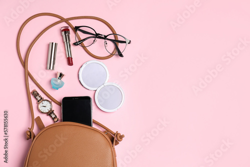 Stylish woman's bag with smartphone and accessories on pink background, flat lay. Space for text