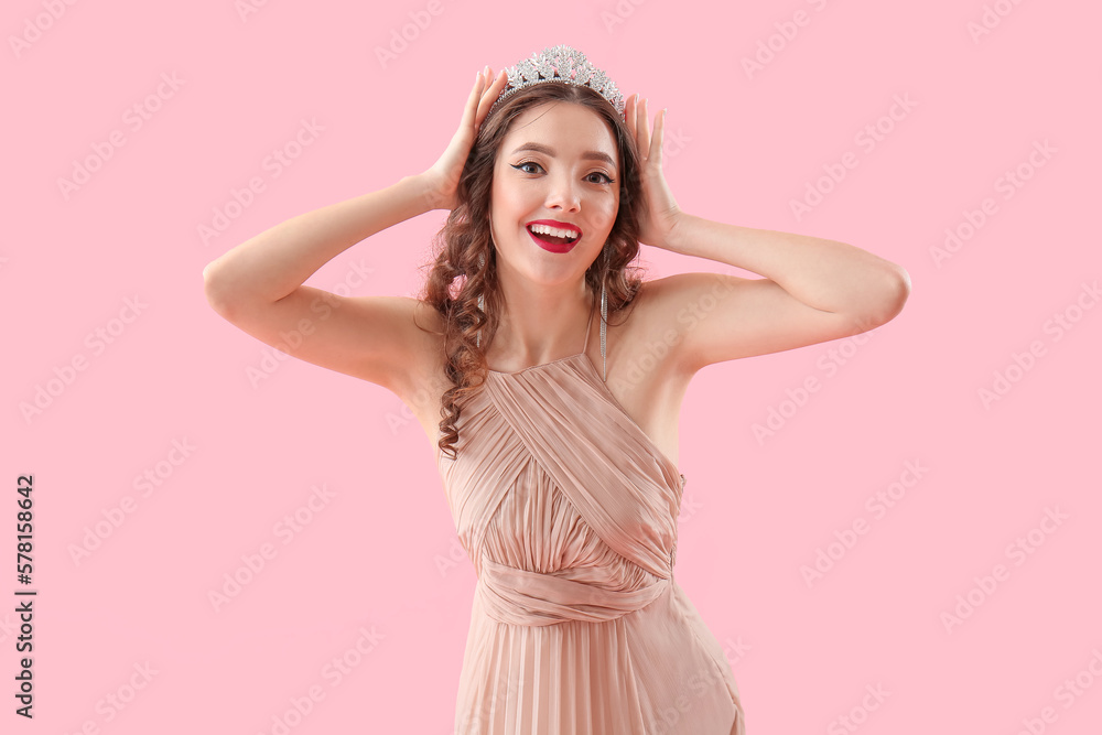 Beautiful young woman in prom dress and tiara on pink background Beautiful young woman in prom dress and tiara on pink background