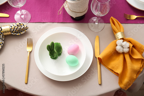Plate with bunny and painted eggs on table served for Easter celebration