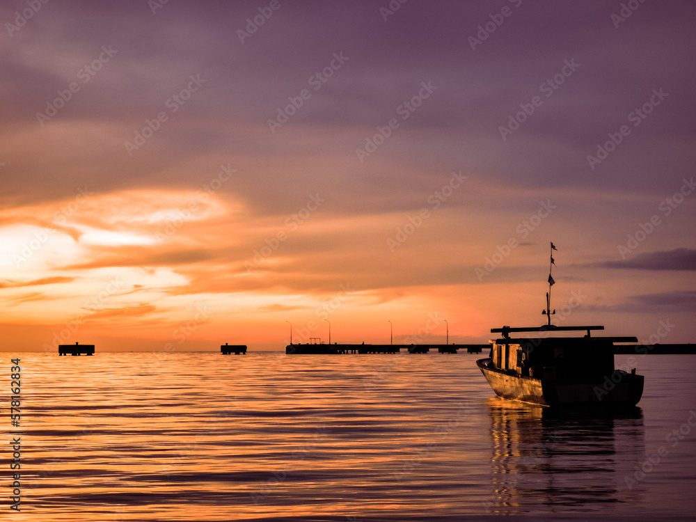 Oudoor scenery during sunset with fisherman's boat in a sea.
