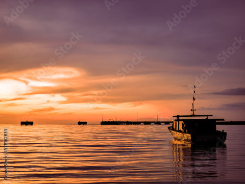 Oudoor scenery during sunset with fisherman's boat in a sea.