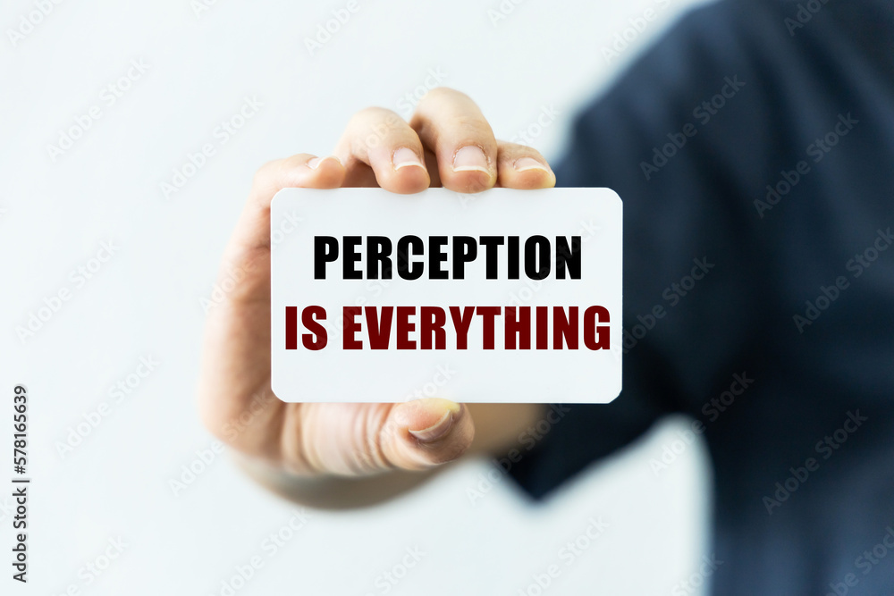 Perception is everything text on blank business card being held by a woman's hand with blurred background. Business concept about perception. Perception is everything text on blank business card being held by a woman's hand with blurred background. Business concept about perception.