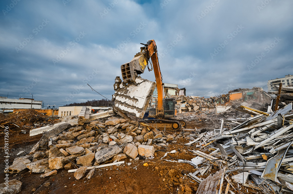 Fototapeta premium Excavator with hydraulic press breaks concrete leftovers