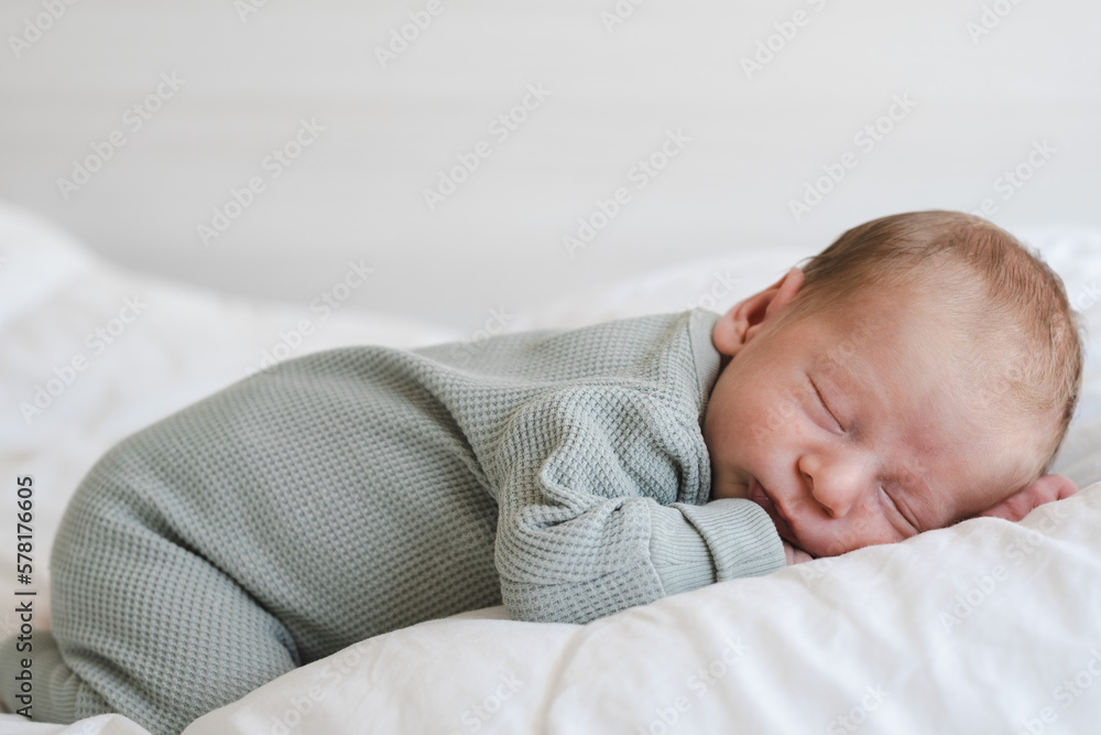 Cute caucasian several days old newborn sleeping on white blanket at home.Adorable,calm, innocent baby indoors.Copy space. Full body shot.Minimalism,lifestyle. Close-up shot Cute caucasian several days old newborn sleeping on white blanket at home.Adorable,calm, innocent baby indoors.Copy space. Full body shot.Minimalism,lifestyle. Close-up shot