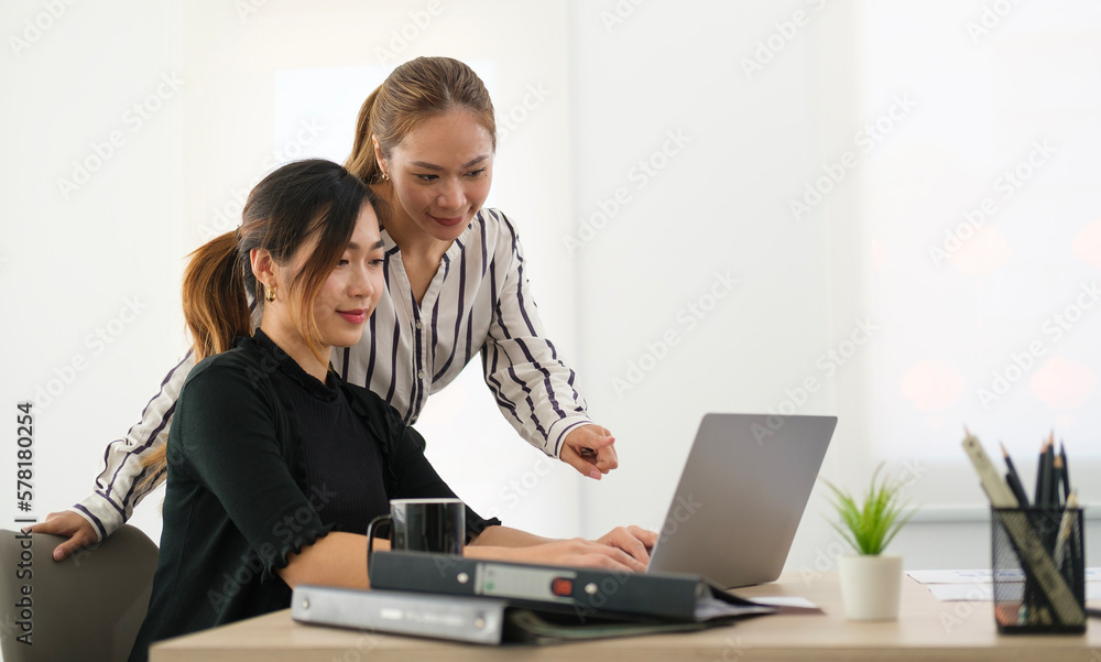 Two business women discussing business data with computer laptop at modern office.. Two business women discussing business data with computer laptop at modern office..