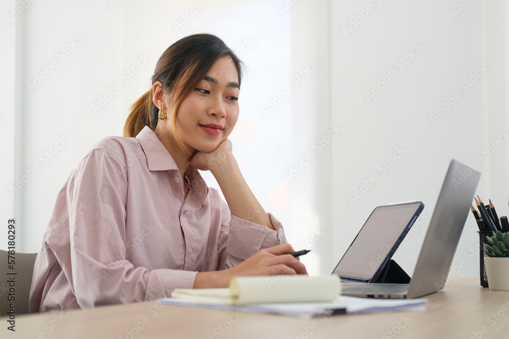 Concentrated female business leader sitting in bright office and analysing financial graph on computer screen. Concentrated female business leader sitting in bright office and analysing financial graph on computer screen.