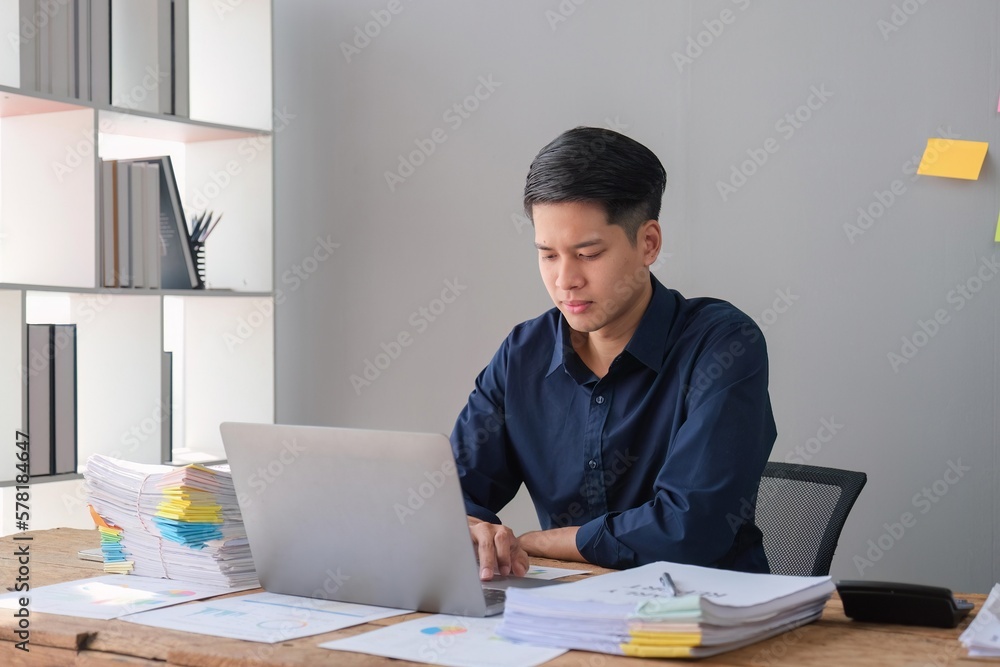 Businessman using a laptop working with documents in office