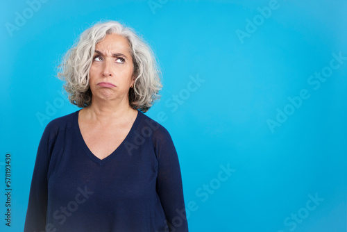 Fototapeta Mature woman looking up with an expression of discontent