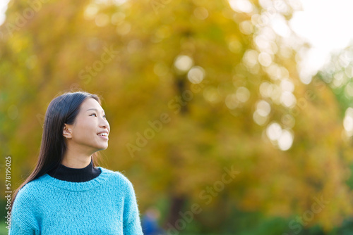 Distracted asian woman looking up in a park