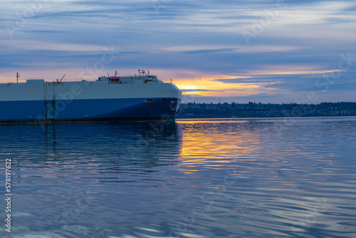 A ship carrying cars across the ocean. RORO. Freight transport. Evening, sunset, winter. Seattle