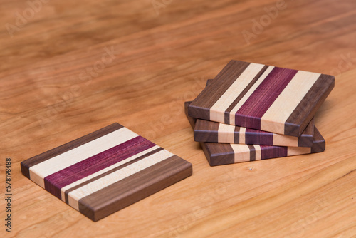 Set of four hardwood coasters with different layers of maple, walnut, purple heart and cherry