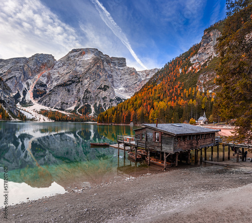 Lake Braies, Italy - Beautiful autumn morning at Lake Braies (Lago di Braies) in the Italian Dolomites at South Tyrol with wooden boats, wooden cabin blue sky and reflecting Seekofel Mountain