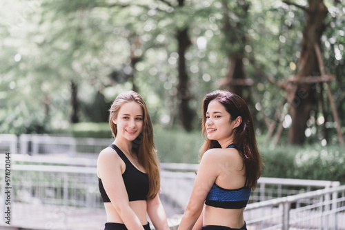 Fit young women take a break after workout together at green park