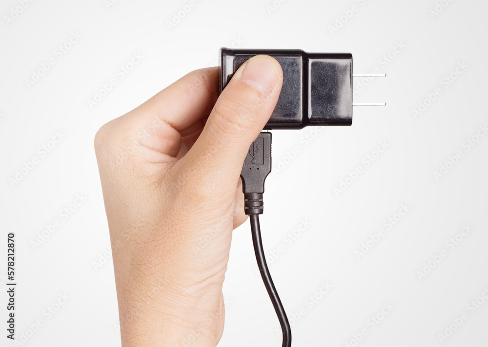 closeup hand holding power plug adapter closeup hand holding power plug adapter