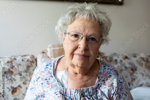 Portrait of a beautiful old woman with gray hair and glasses