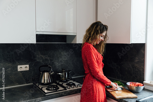 a woman in the kitchen prepares food salad healthy food near the sink