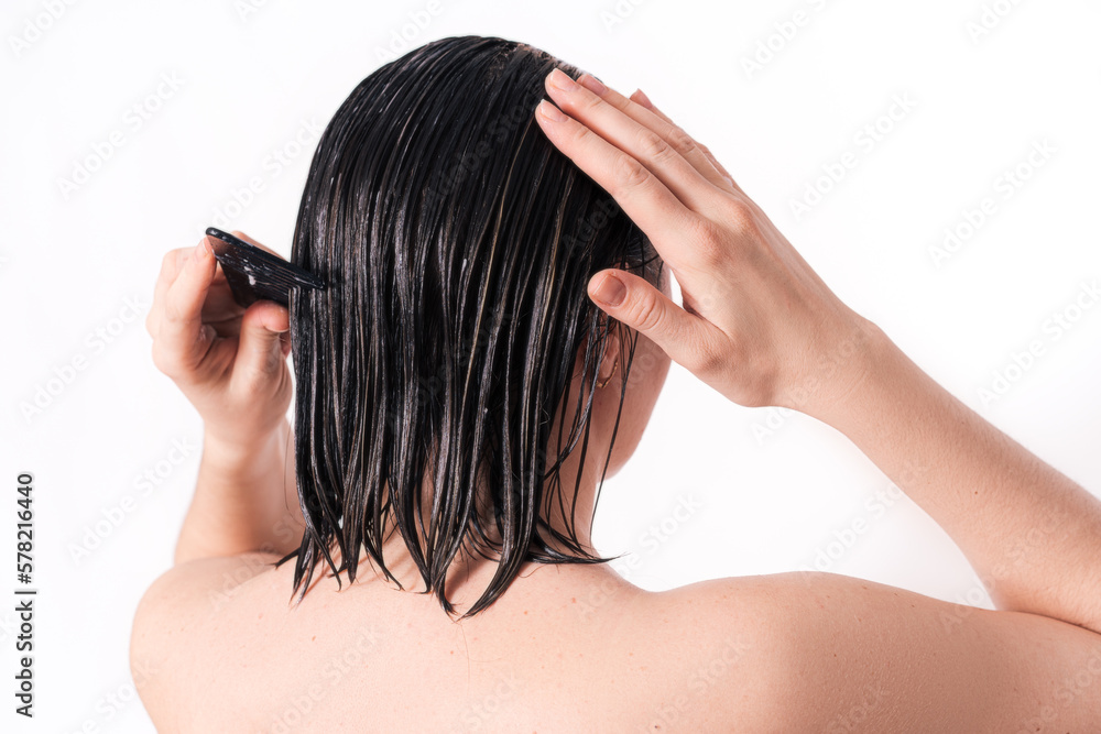 Lady applying hair mask with comb against white background. Lady applying hair mask with comb against white background.
