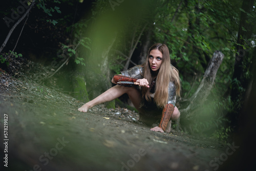 Fototapeta Naklejka Na Ścianę i Meble -  Girl warrior with the knife is hunting in the forest concept.
