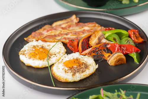 Healthy Breakfast of Fried eggs with bacon and grilled veggies 