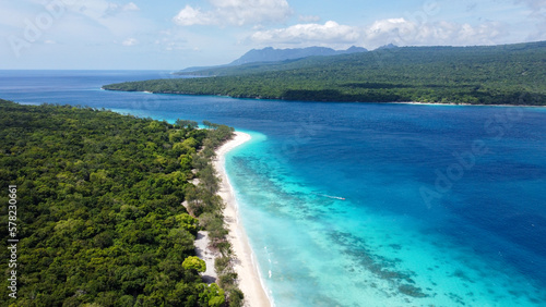 Aerial view of remote, uninhabited Jaco Island and mainland Timor Leste, Southeast Asia, tropical island destination with white sandy beaches and stunning turquoise ocean views © Adam Constanza