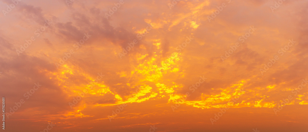 Photo of the golden hour sky, soft clouds covered the sky, panoramic image, orange tones, natural phenomenon background.