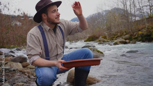 smiling and happy portrait of a male gold digger with wash gold Panning mining
