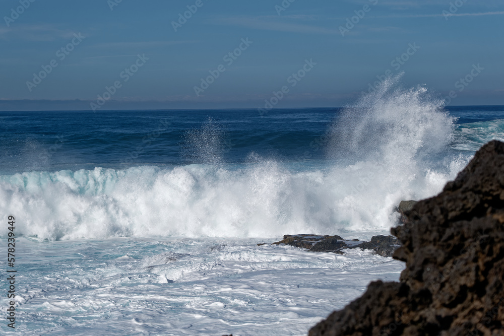 waves crashing on vulcanic rocks