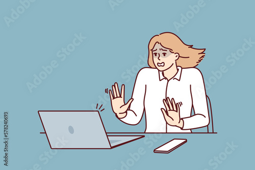 Frightened businesswoman sitting at table and looking at laptop after seeing cash gap notice in own company. Shocked businesswoman after error or notification about presence of viruses in computer 